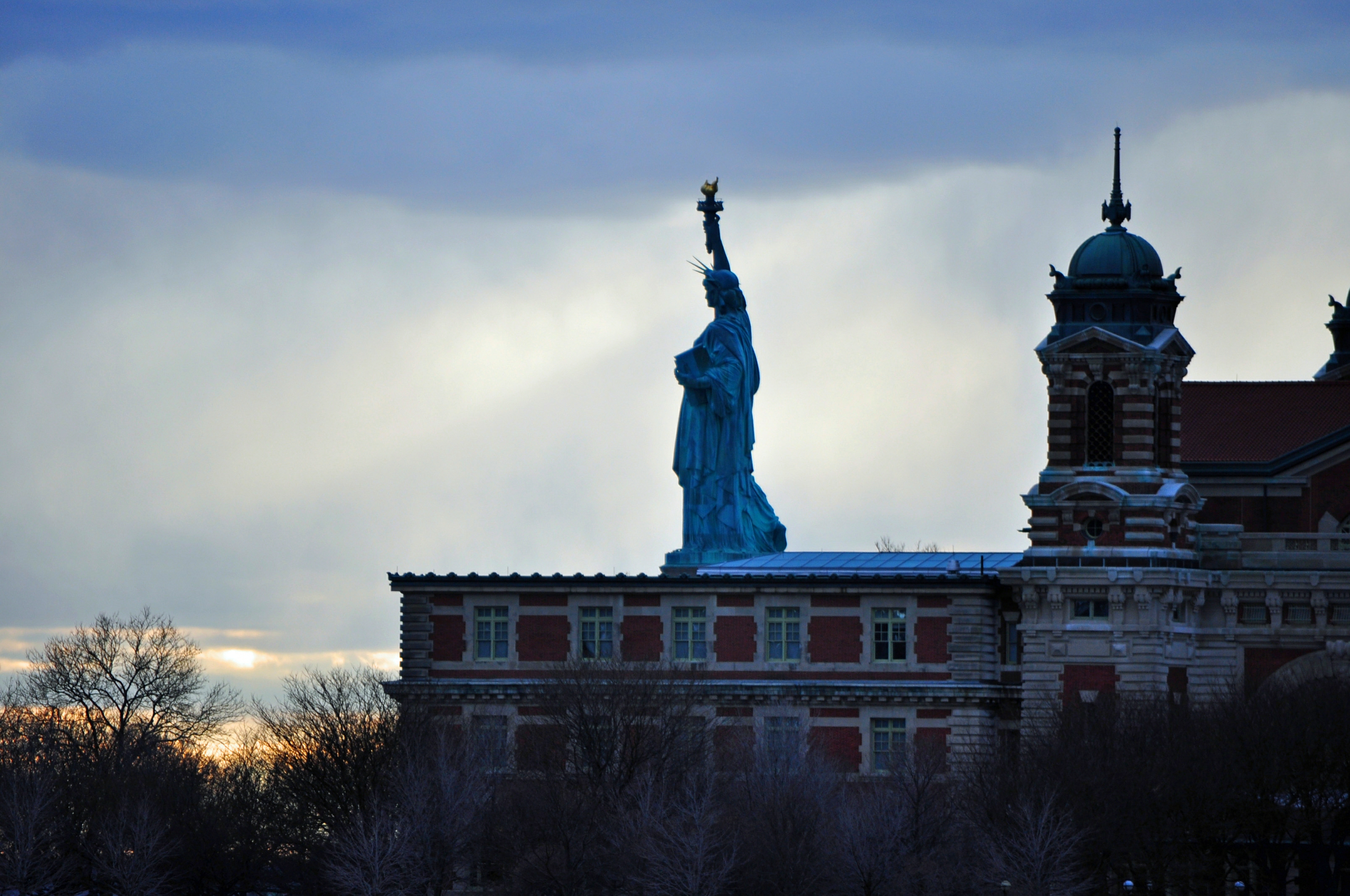 A photograph of Ellis Island with the Statue of Liberty in the background